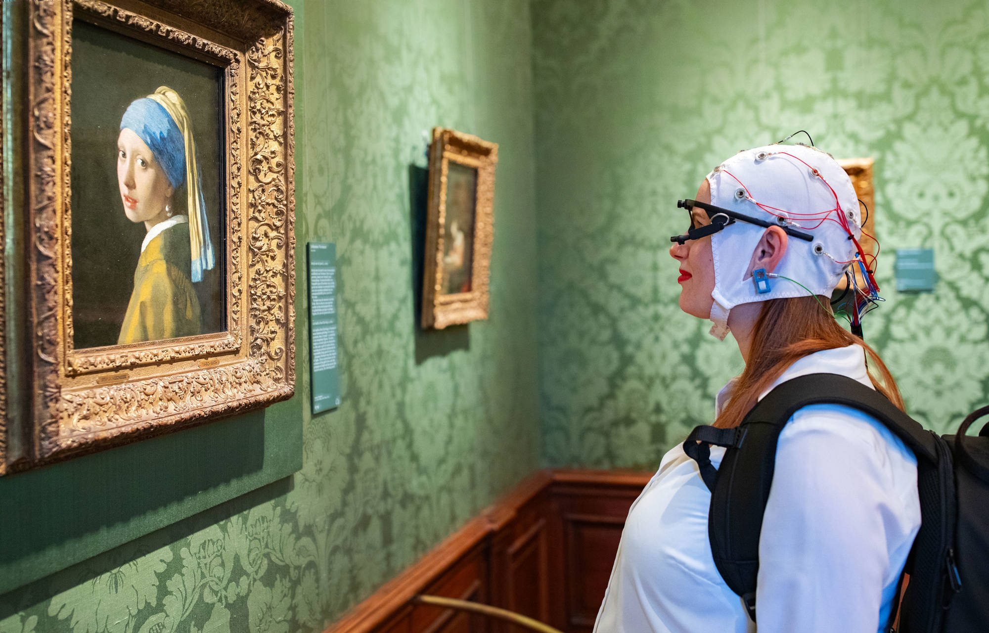 Visitor with measurement equipment in front of Girl with a Pearl Earring at the Mauritshuis