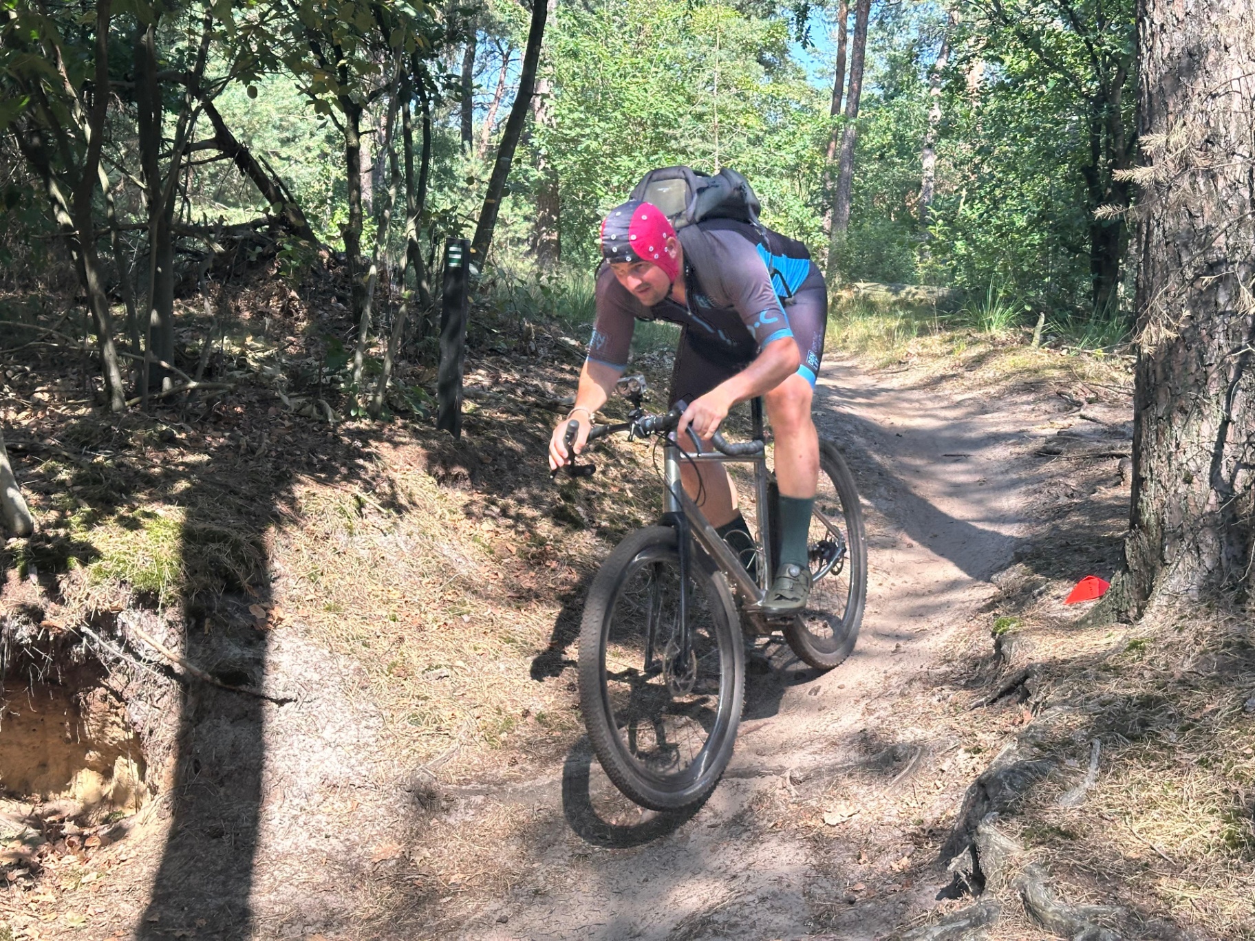Gravel rider on a titanium Pilot bike on a forest trail